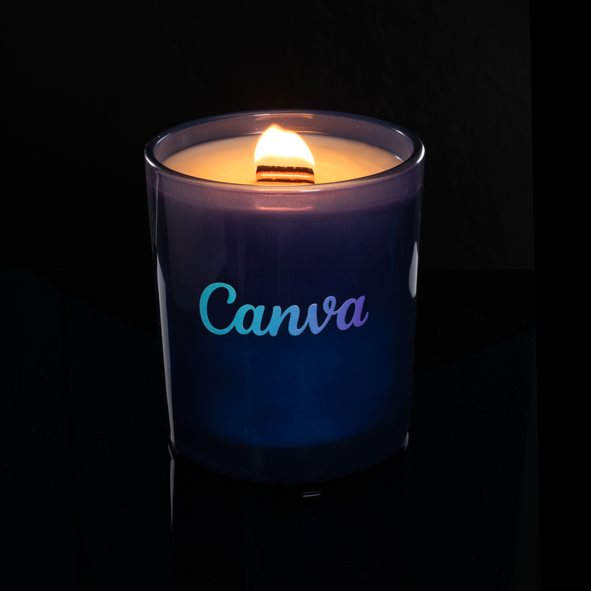 14 oz. Blue glass candle with custom printed logo from Bath Promotions, shown lit — Lit version
