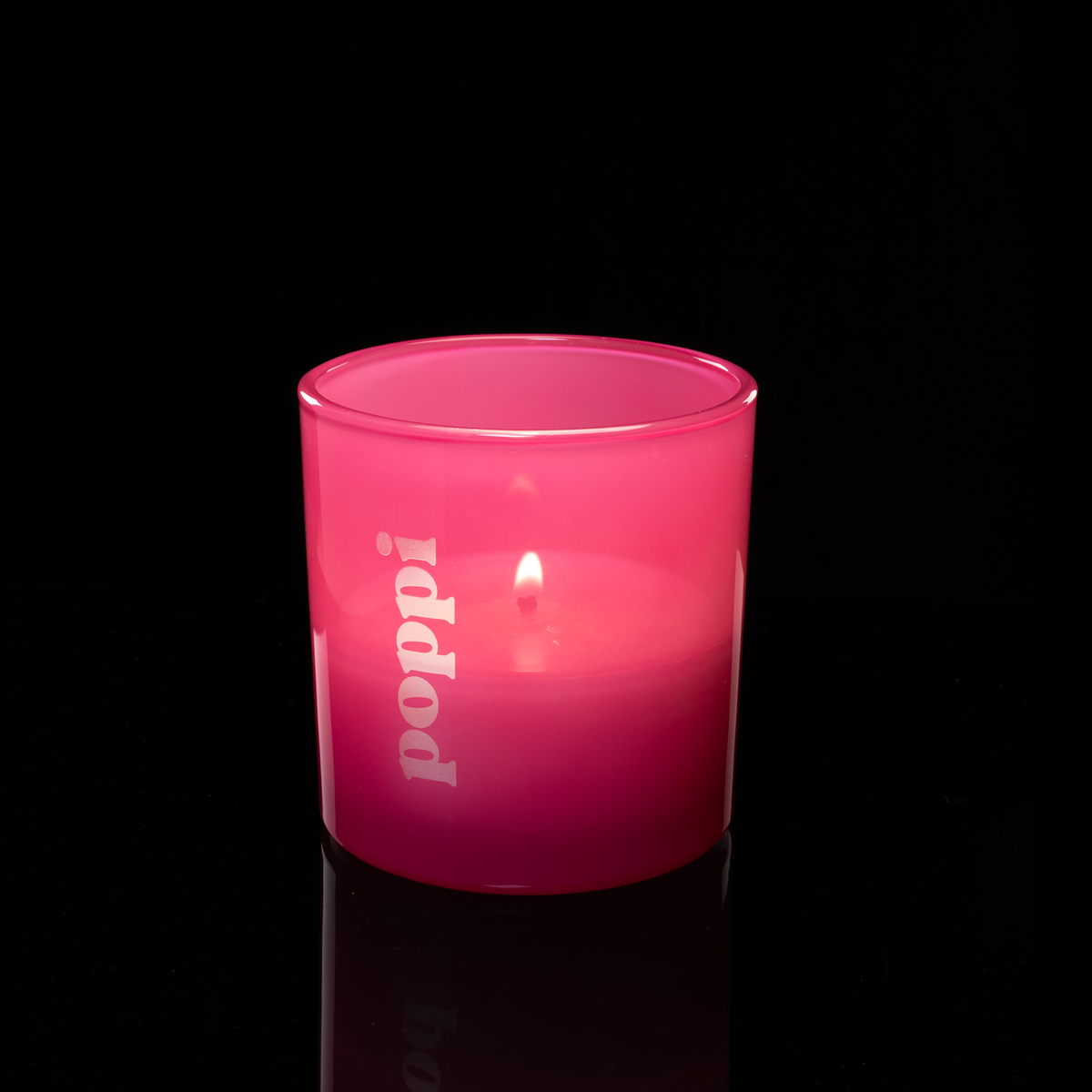 9 oz. Pink glass candle with custom engraved logo from Bath Promotions, shown lit — Lit version