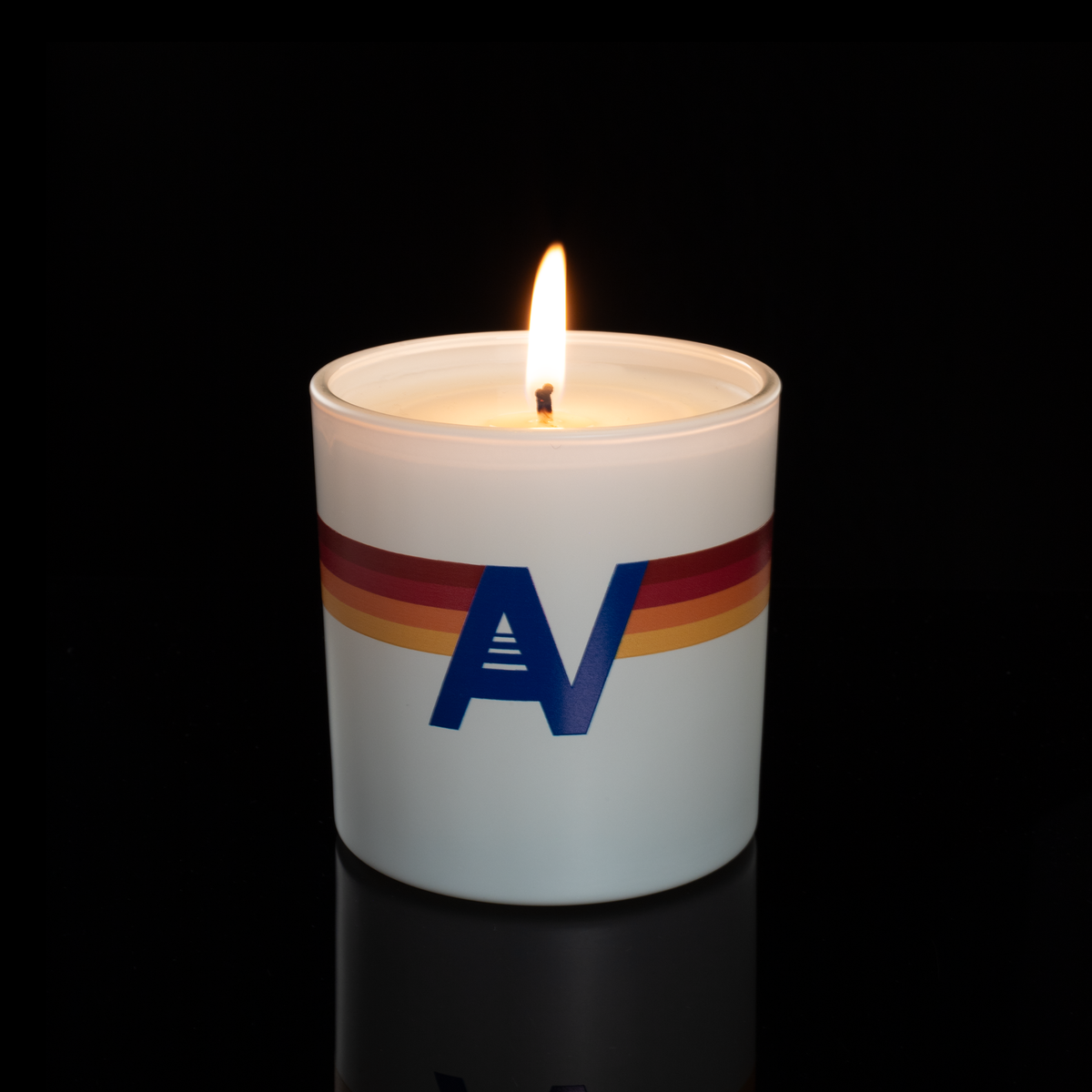 9 oz. White glass candle with custom printed logo from Bath Promotions, shown lit — Lit version