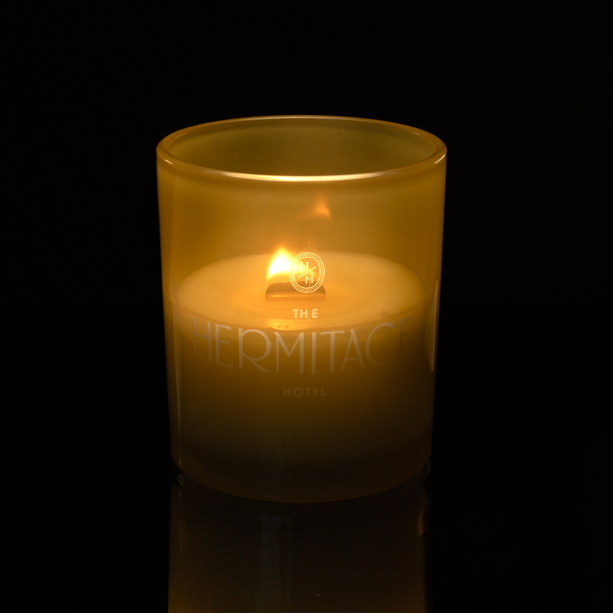 14 oz. Yellow glass candle with custom engraved logo from Bath Promotions, shown lit — Lit version