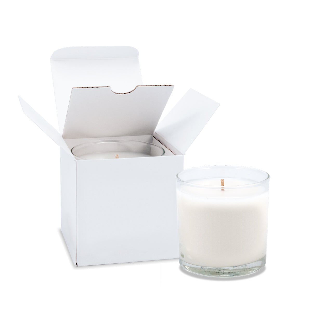 Two 6 oz clear glass candles with white wax and cotton wicks - one inside an open white gift box and one standing beside it.