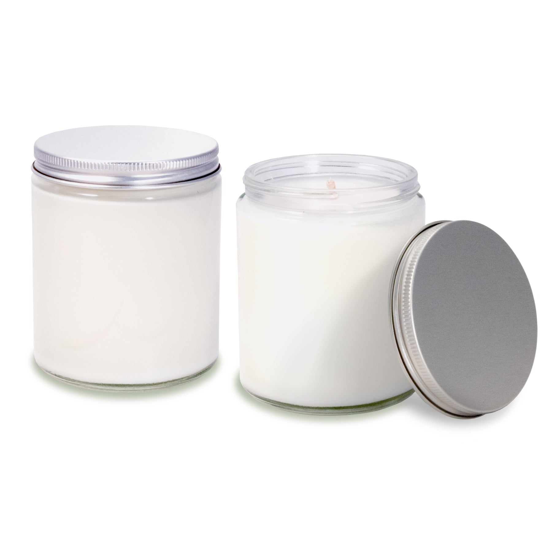 Two 8 oz clear glass apothecary jar candles with silver screw-on lids. One jar is closed with lid on top, the other is open showing the lit candle inside with the lid placed beside it