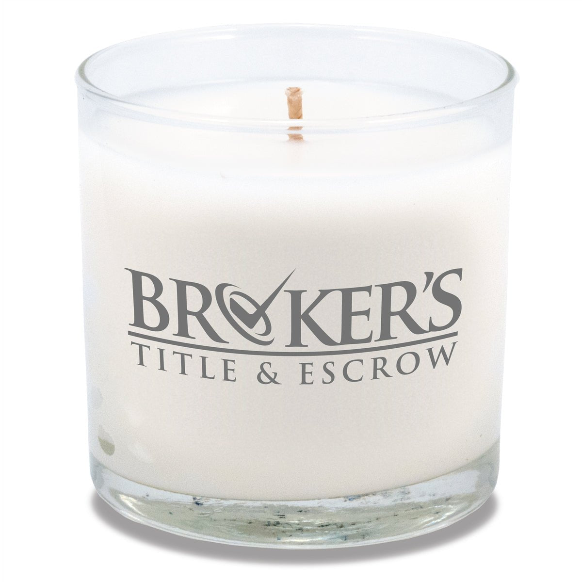 6 oz clear glass candle with white wax and cotton wick in cylindrical vessel decorated with bold gray logo.