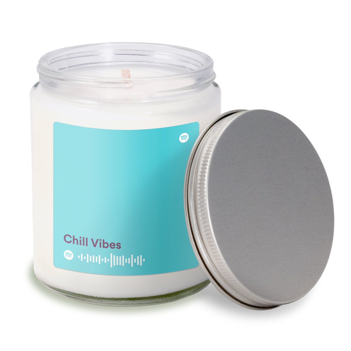 8 oz clear glass apothecary jar candle with silver screw-on lid off to the side, featuring a turquoise label.