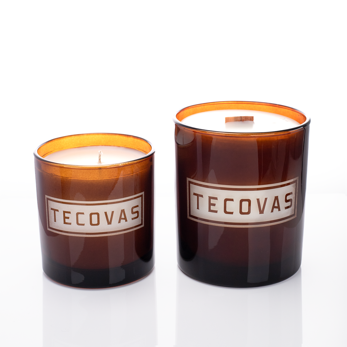 Amber glass candles, 9 oz. beside 14 oz., both laser engraved with the same logo, from Bath Promotions