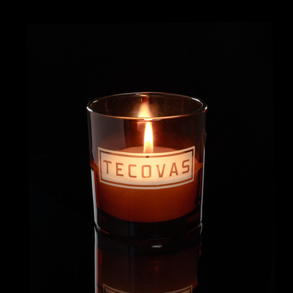 9 oz. Amber glass candle with custom engraved logo from Bath Promotions, shown lit — Lit version
