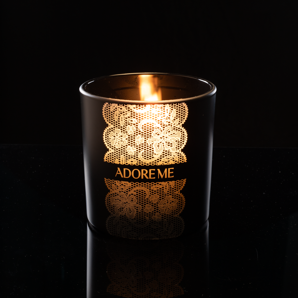 9 oz. Black glass candle with custom engraved logo from Bath Promotions, shown lit — Lit version