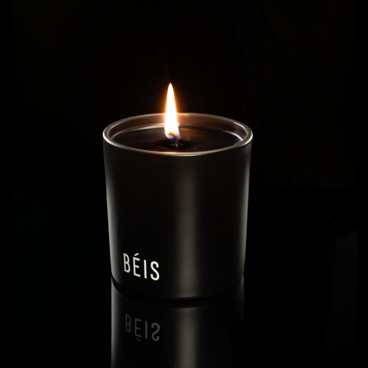 9 oz. Black glass candle with custom printed logo from Bath Promotions, shown lit — Lit version