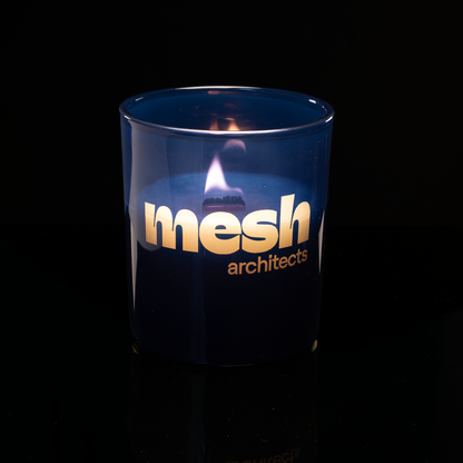 14 oz. Blue glass candle with custom engraved logo from Bath Promotions, shown lit — Lit version