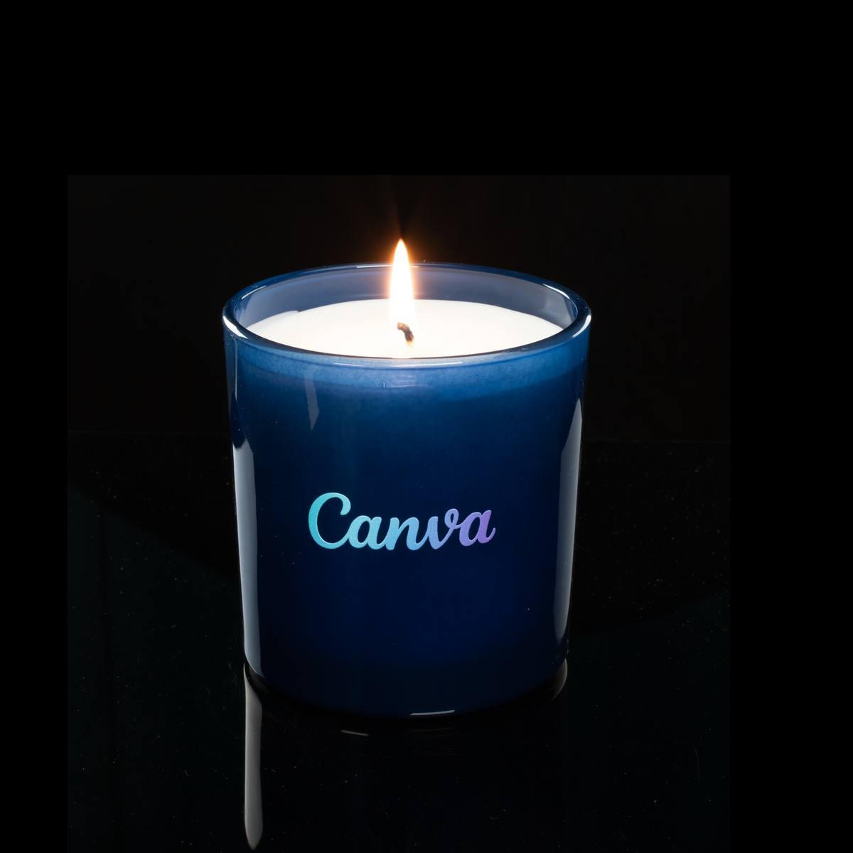 9 oz. Blue glass candle with custom printed logo from Bath Promotions, shown lit — Lit version