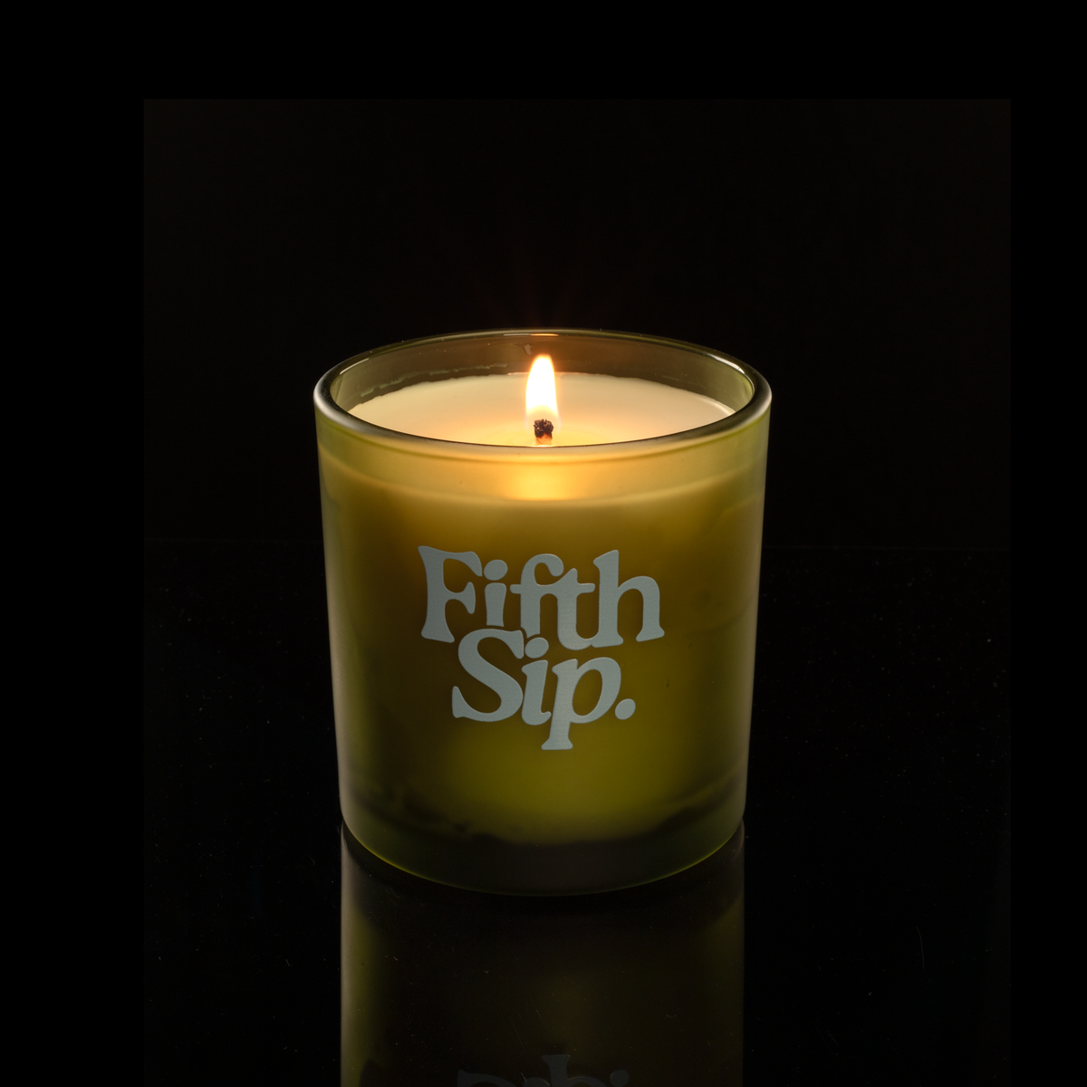 9 oz. Green glass candle with custom printed logo from Bath Promotions, shown lit — Lit version