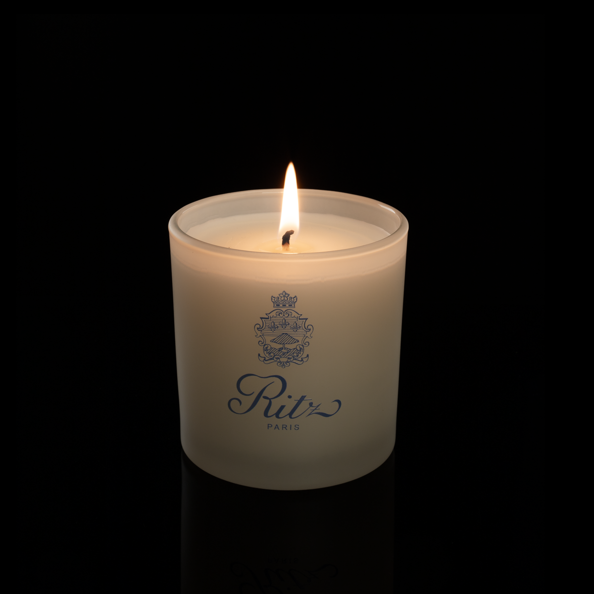 9 oz. Ivory glass candle with custom printed logo from Bath Promotions, shown lit — Lit version