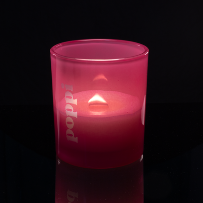 14 oz. Pink glass candle with custom engraved logo from Bath Promotions, shown lit — Lit version