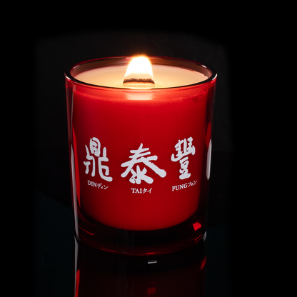 14 oz. Red glass candle with custom printed logo from Bath Promotions, shown lit — Lit version