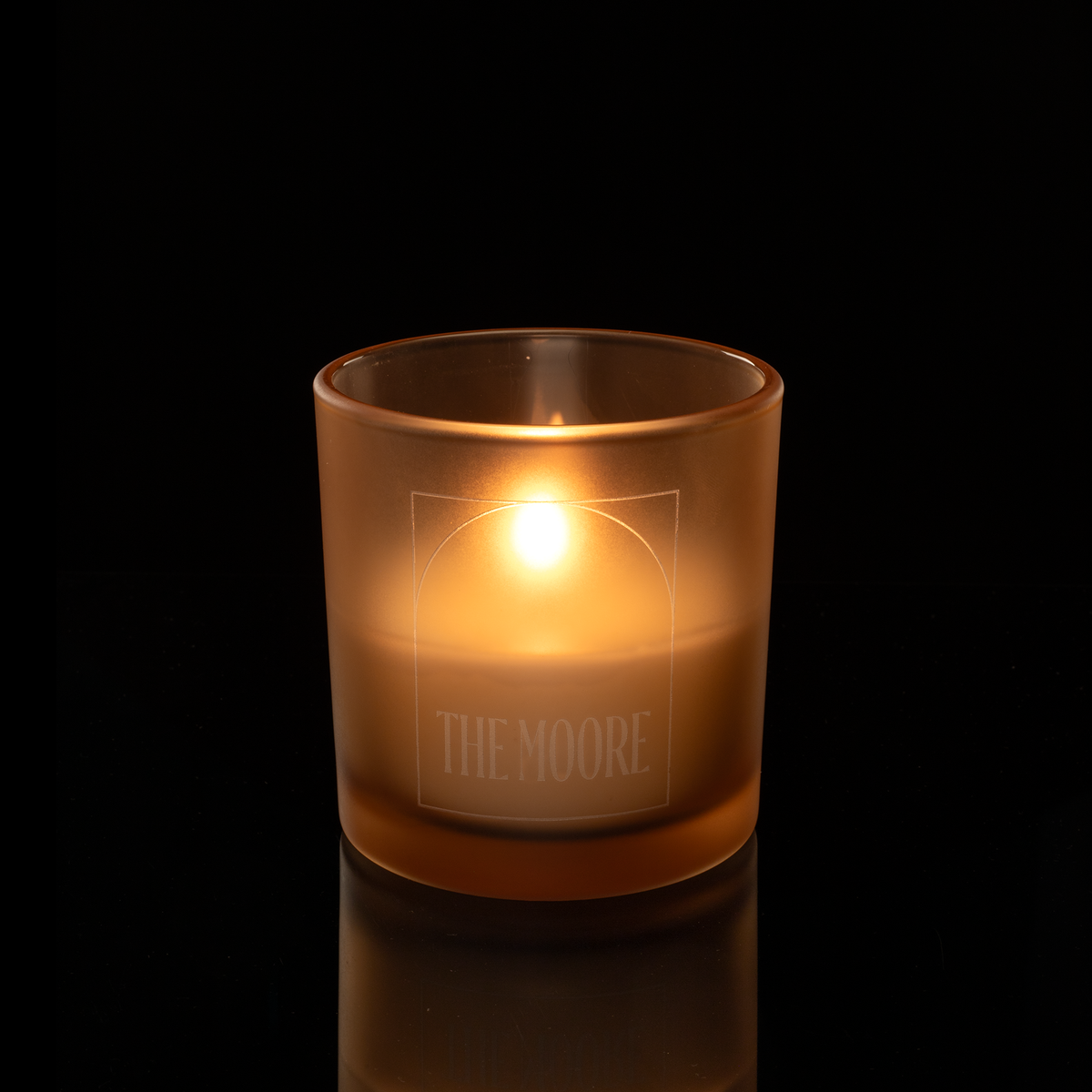 9 oz. Sand glass candle with custom engraved logo from Bath Promotions, shown lit — Lit version
