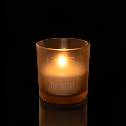 9 oz. Sand glass candle with custom engraved logo from Bath Promotions, shown lit — Lit version