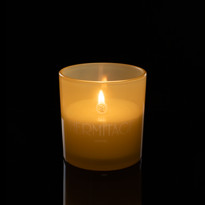 9 oz. Yellow glass candle with custom engraved logo from Bath Promotions, shown lit — Lit version