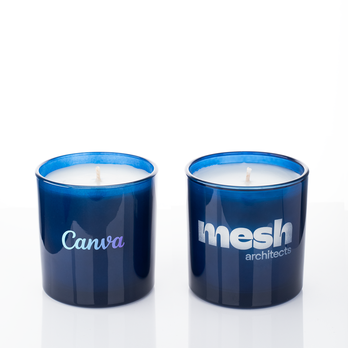 Blue glass, two 9 oz. candles side by side, one custom printed and one laser engraved, from Bath Promotions