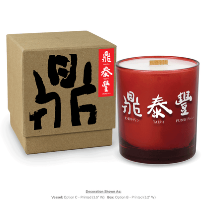 14 oz. Red glass candle with custom printed logo next to its matching Kraft gift box