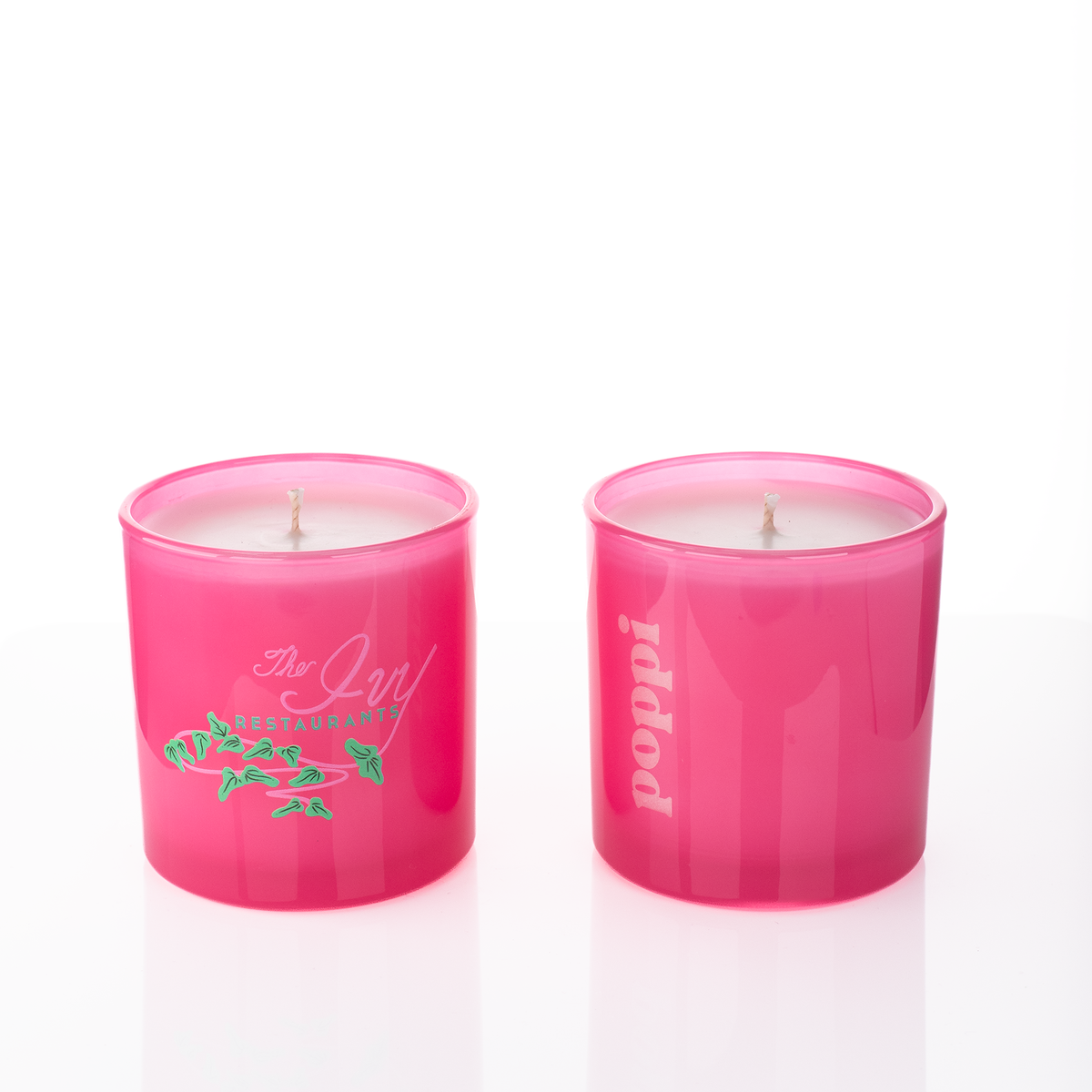 Pink glass, two 9 oz. candles side by side, one custom printed and one laser engraved, from Bath Promotions