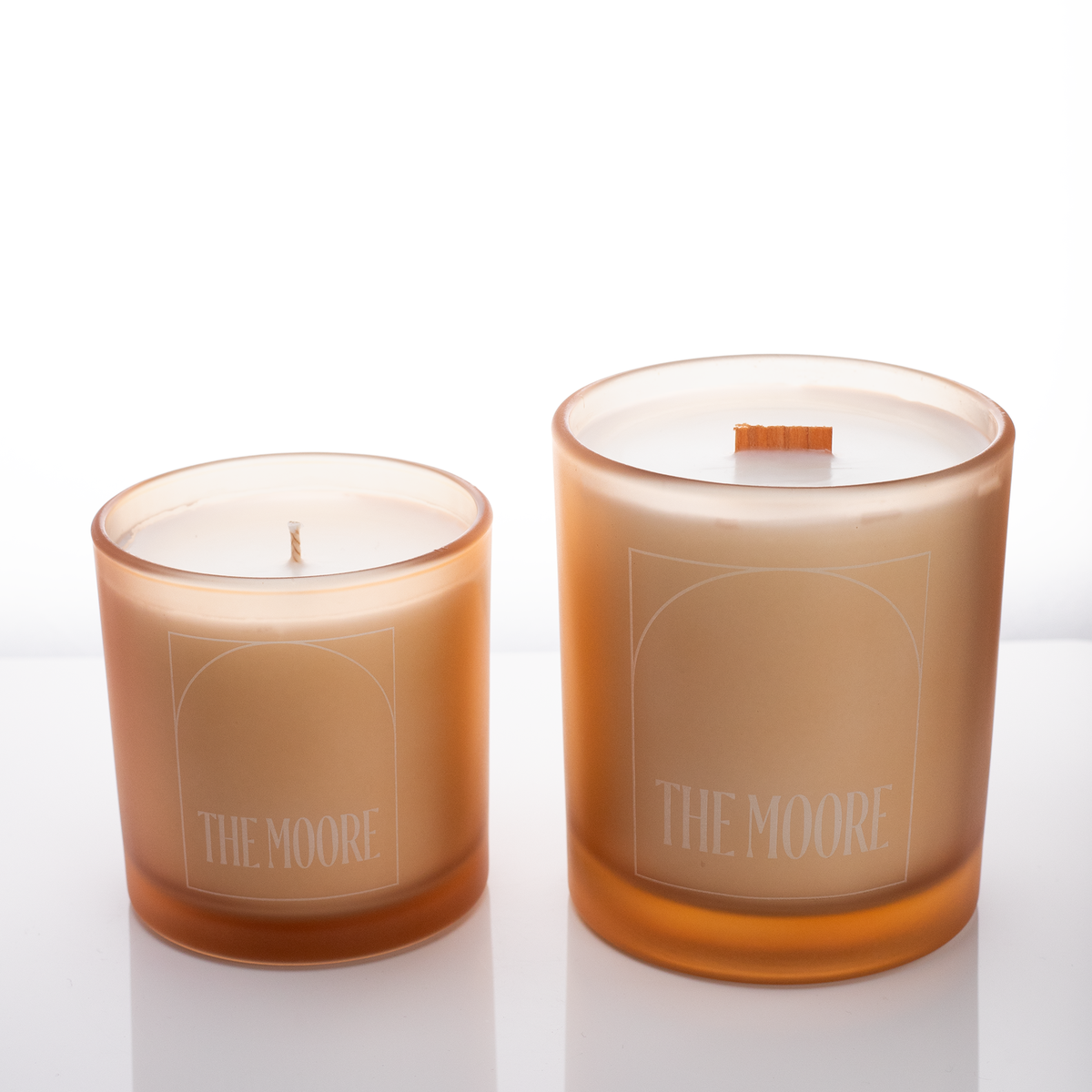 Sand glass candles, 9 oz. beside 14 oz., both laser engraved with the same logo, from Bath Promotions