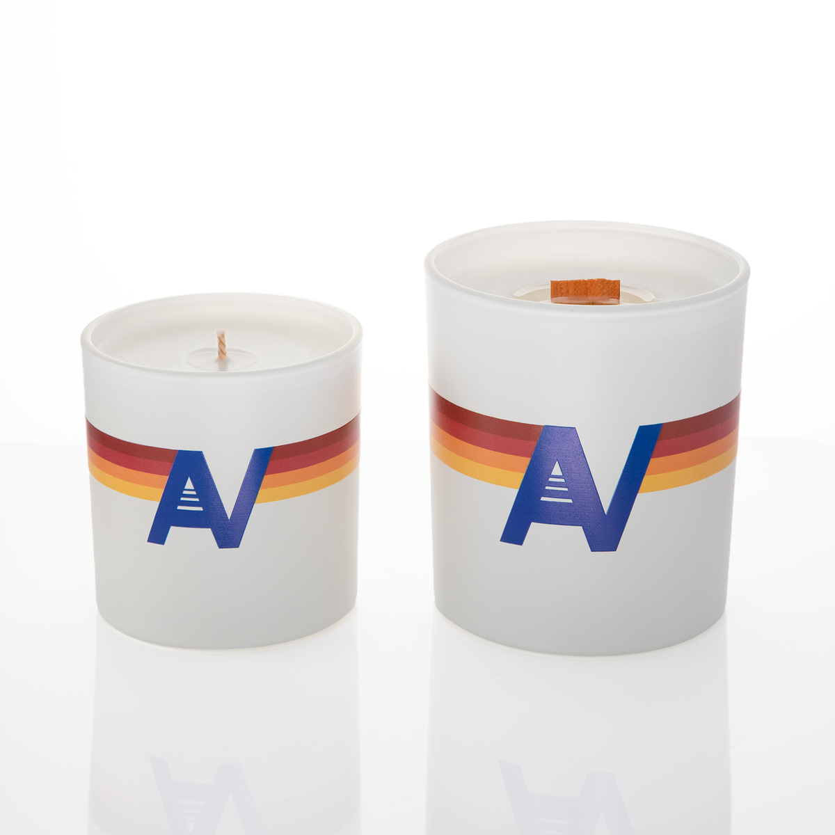 White glass candles, 9 oz. beside 14 oz., both custom printed with the same logo, from Bath Promotions