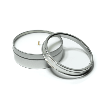 4 oz open silver tin candle with white wax and cotton wick, alongside its clear  lid.