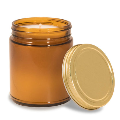 8 oz amber glass apothecary jar candle with gold screw-on lid off to the side.