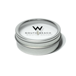2 oz open silver tin candle with white wax and cotton wick, its clear  lid displaying branding in black text.