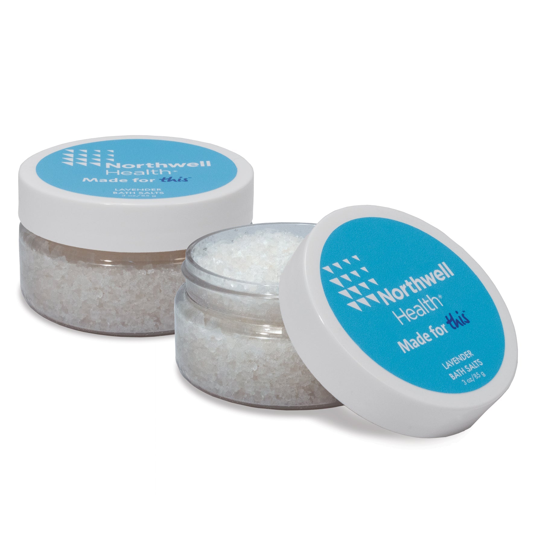 Two 3 oz clear jars with white screw-on lids and blue labels. One jar is closed, the other is open revealing white bath salts inside.