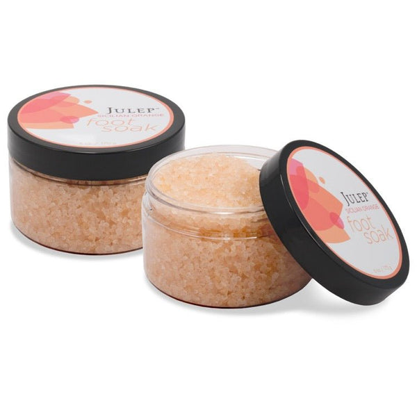 Two 6 oz clear jars with black screw-on lids and 4-color labels. One jar is closed, the other is open revealing white bath salts inside.