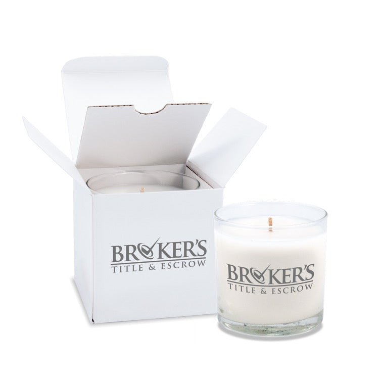 6 oz clear glass candle with white wax and cotton wick featuring gray branding, shown with matching white gift box.