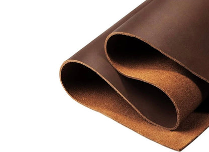 Brown leather material folded and curved to show texture and thickness, displaying rich cognac color with smooth finish against white background.
